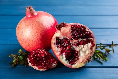 Delicious ripe pomegranates on blue wooden table