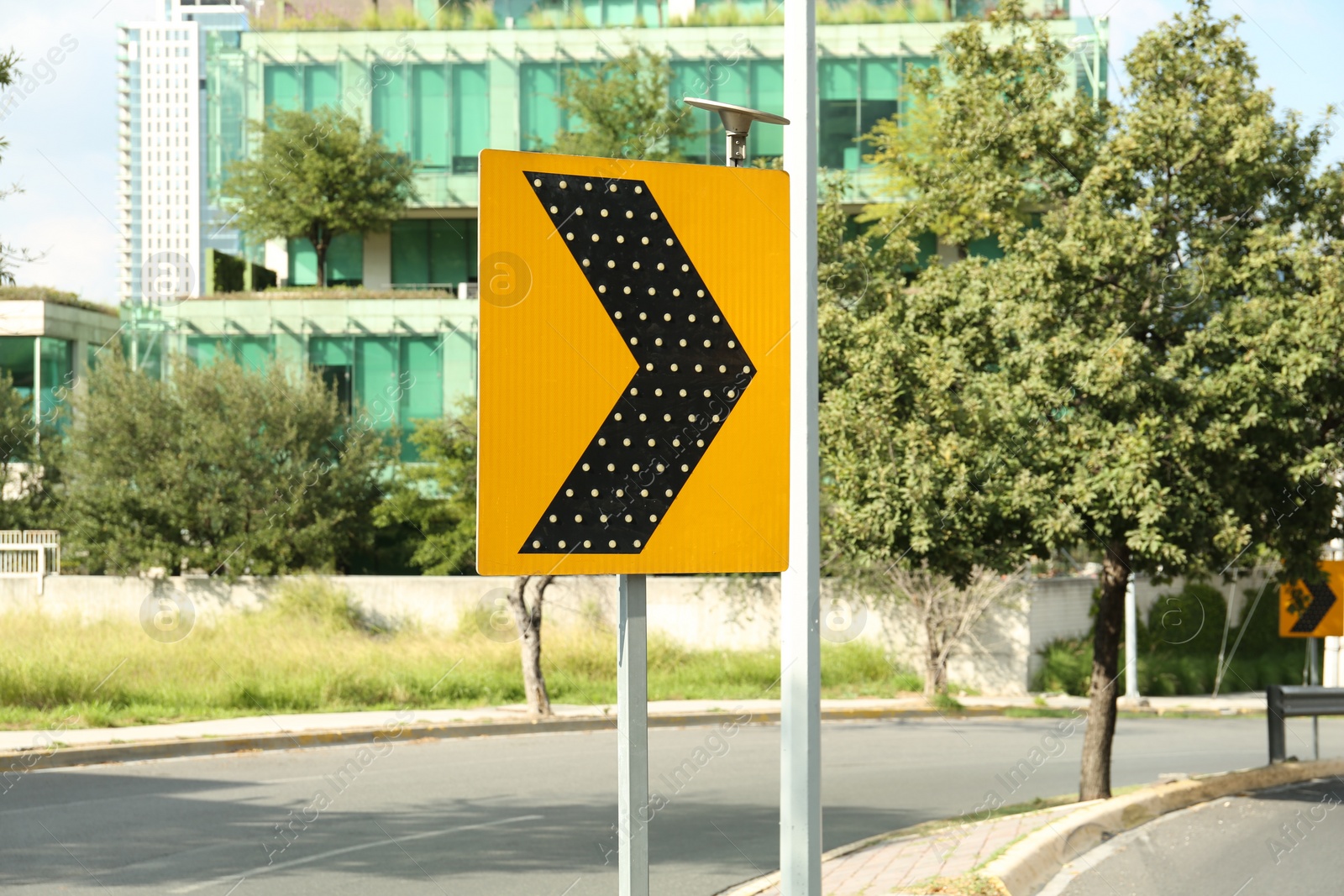 Photo of Yellow arrow road sign on city street