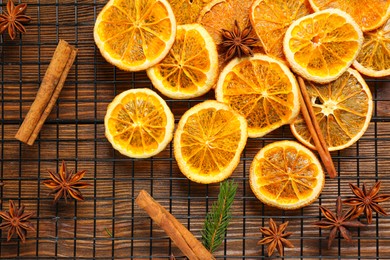 Photo of Flat lay composition with dry orange slices, anise stars and cinnamon sticks on wooden table