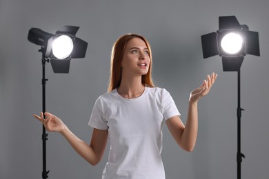 Casting call. Emotional woman performing on grey background in studio