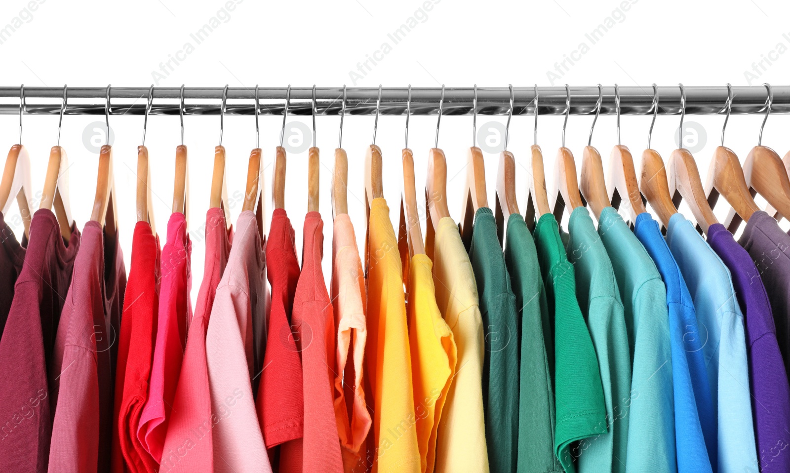 Photo of Rack with rainbow clothes on light background