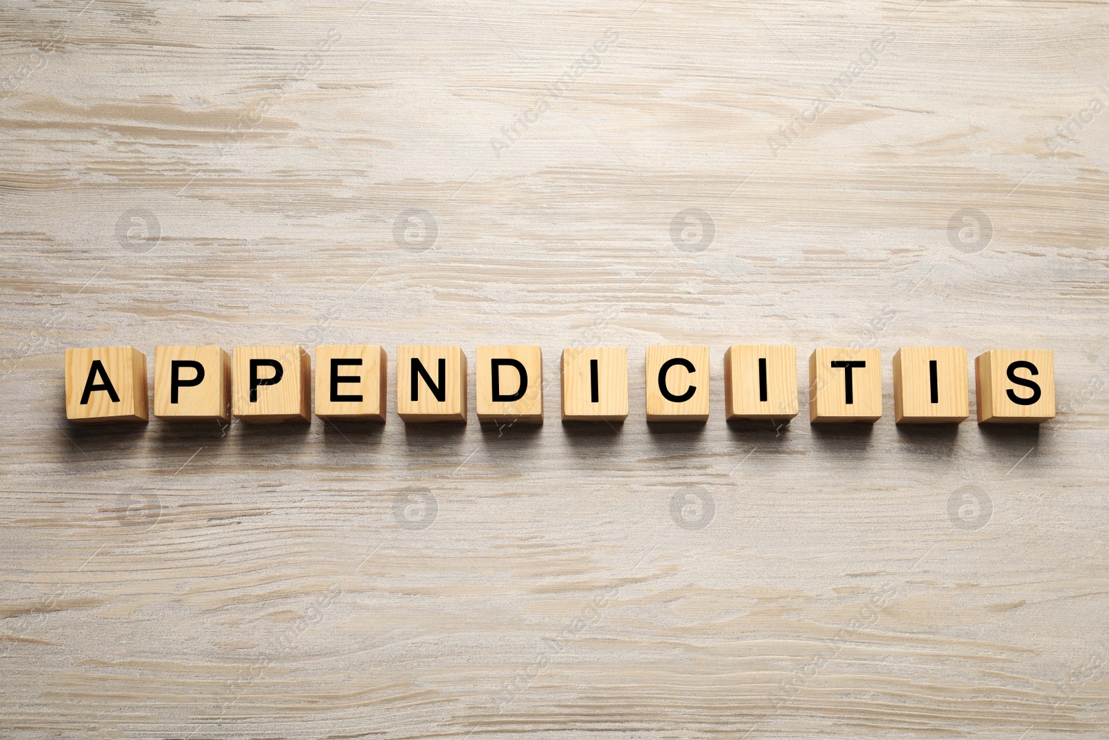 Photo of Word Appendicitis made of cubes with letters on wooden table, top view