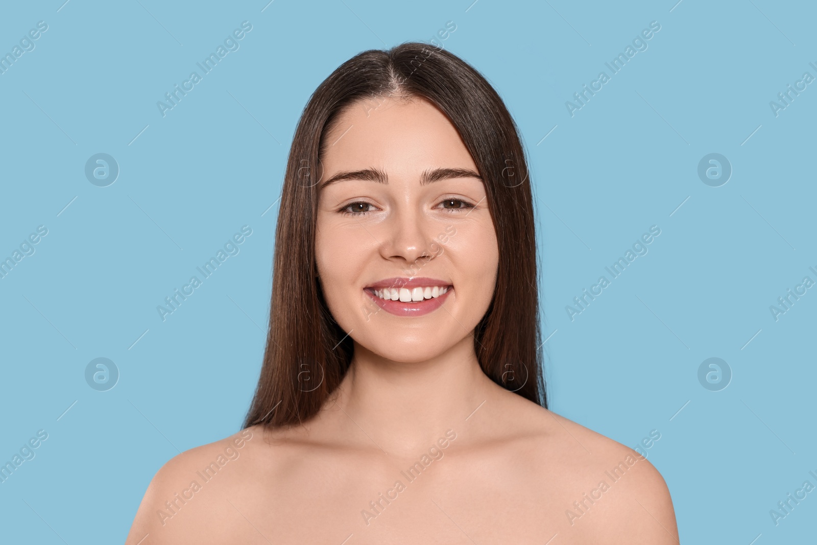 Photo of Portrait of attractive young woman on light blue background. Spa treatment