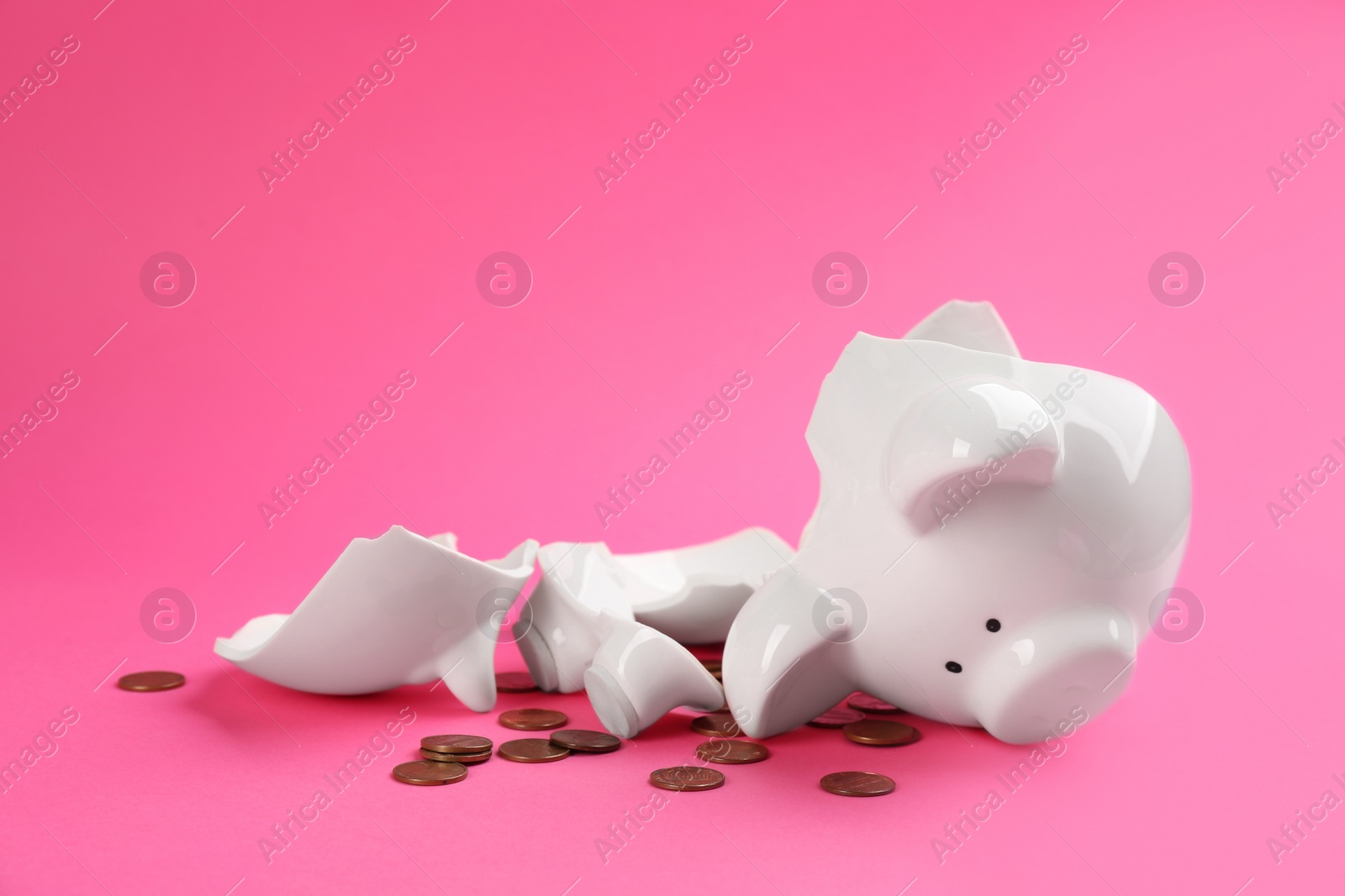 Photo of Broken piggy bank with coins on pink background