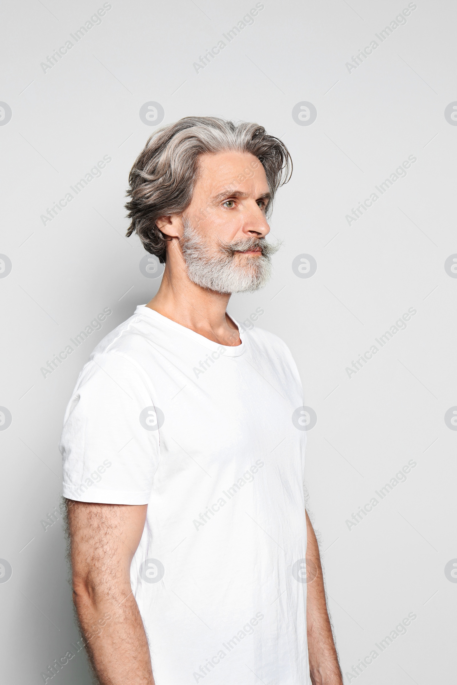 Photo of Portrait of charming mature man on light grey background