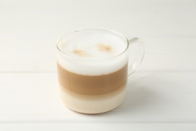 Photo of Aromatic coffee in glass cup on white wooden table, closeup