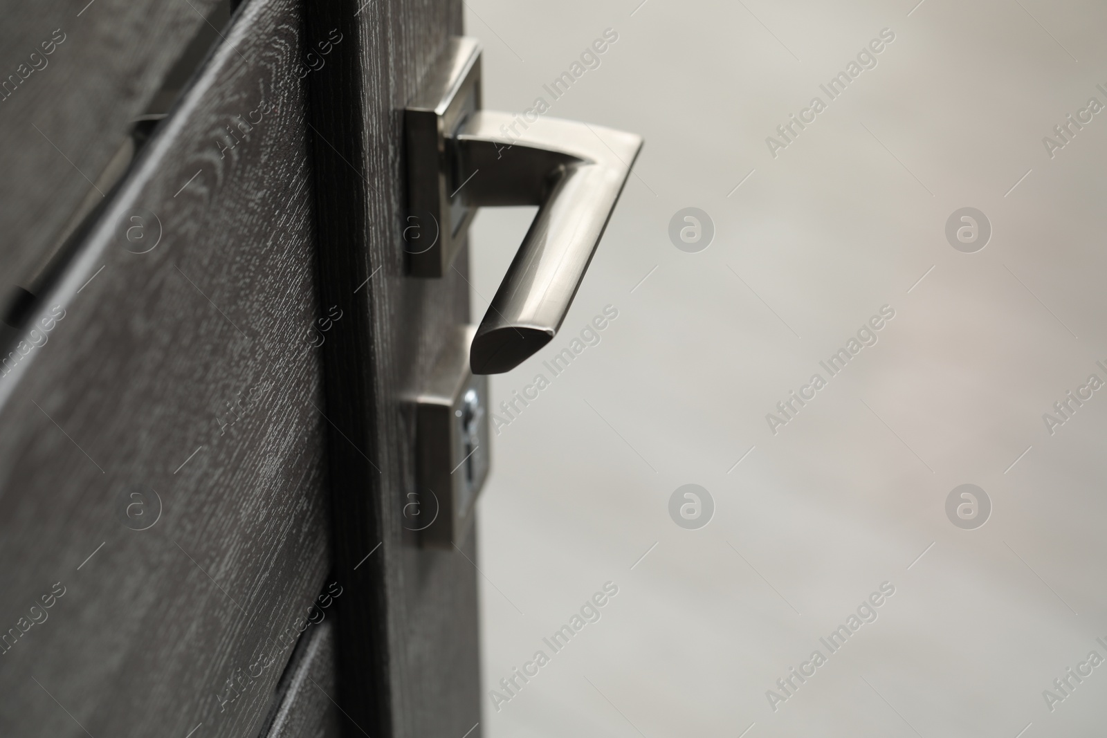 Photo of Open wooden door with metal handle, closeup