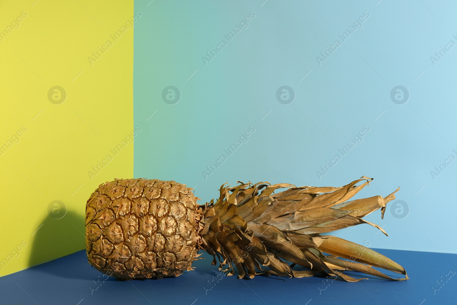 Photo of Golden pineapple on color background, space for text. Creative concept