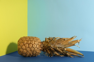 Golden pineapple on color background, space for text. Creative concept
