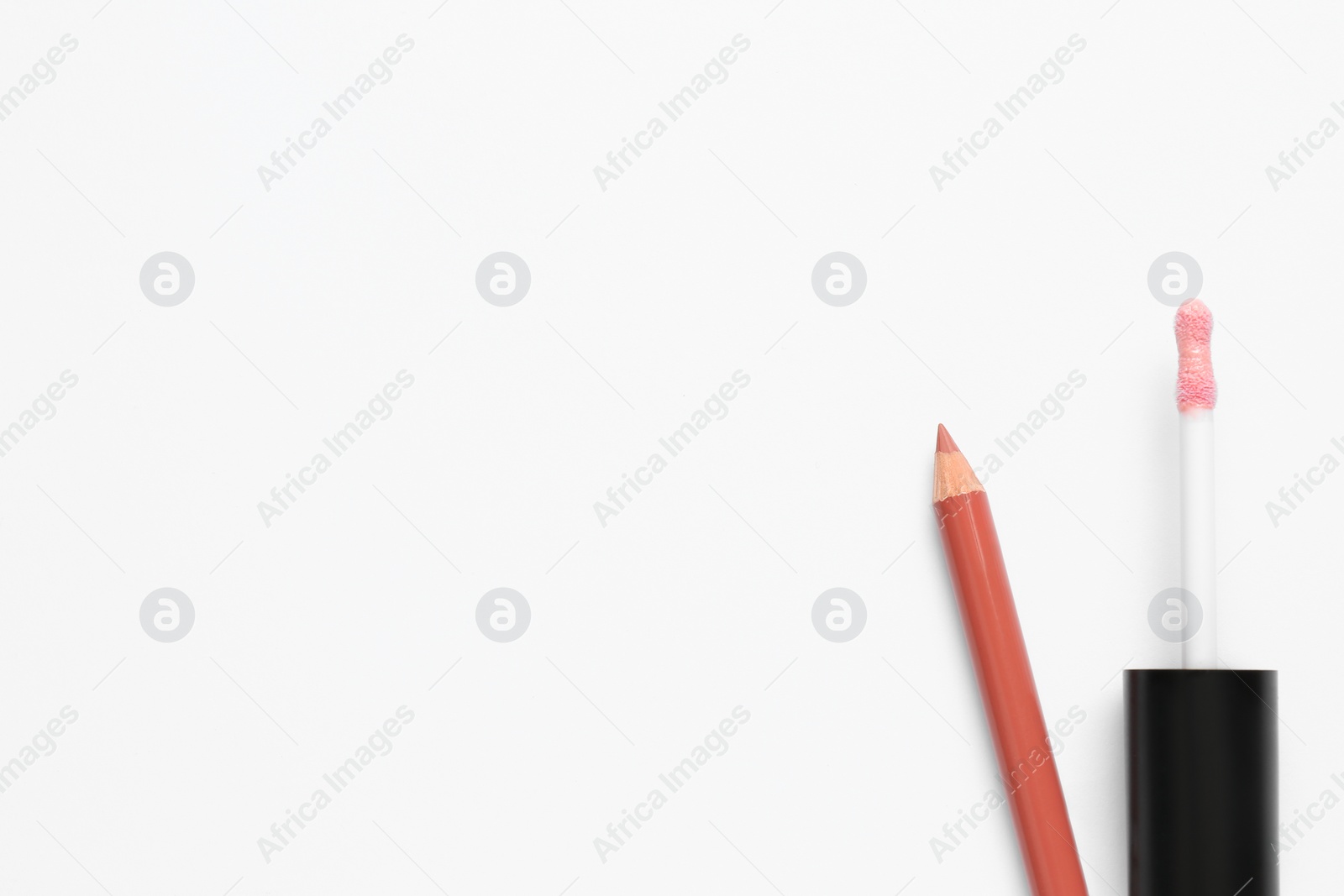 Photo of Lip pencil and brush of liquid lipstick on white background, top view. Cosmetic product