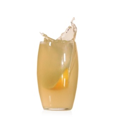 Photo of Lemon slice falling into glass of juice on white background