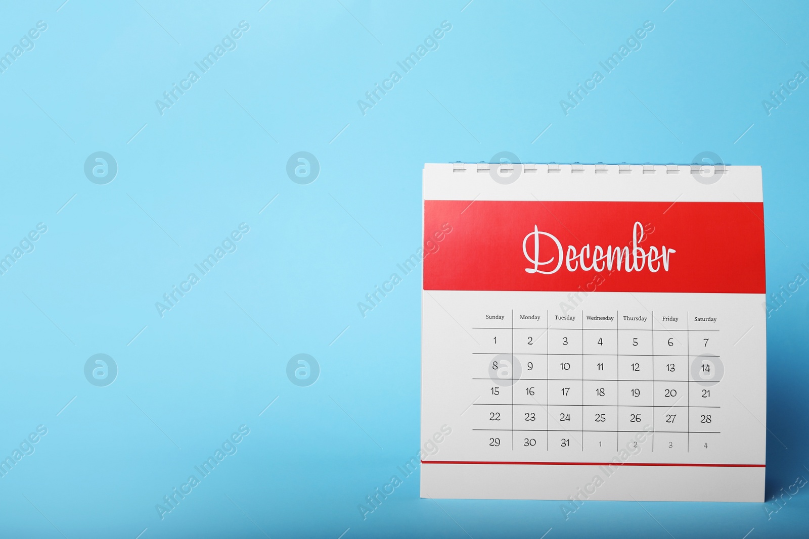 Photo of Paper calendar on light blue background, space for text. Planning concept