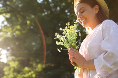 Photo of Young woman with beautiful bouquet outdoors on sunny day, space for text