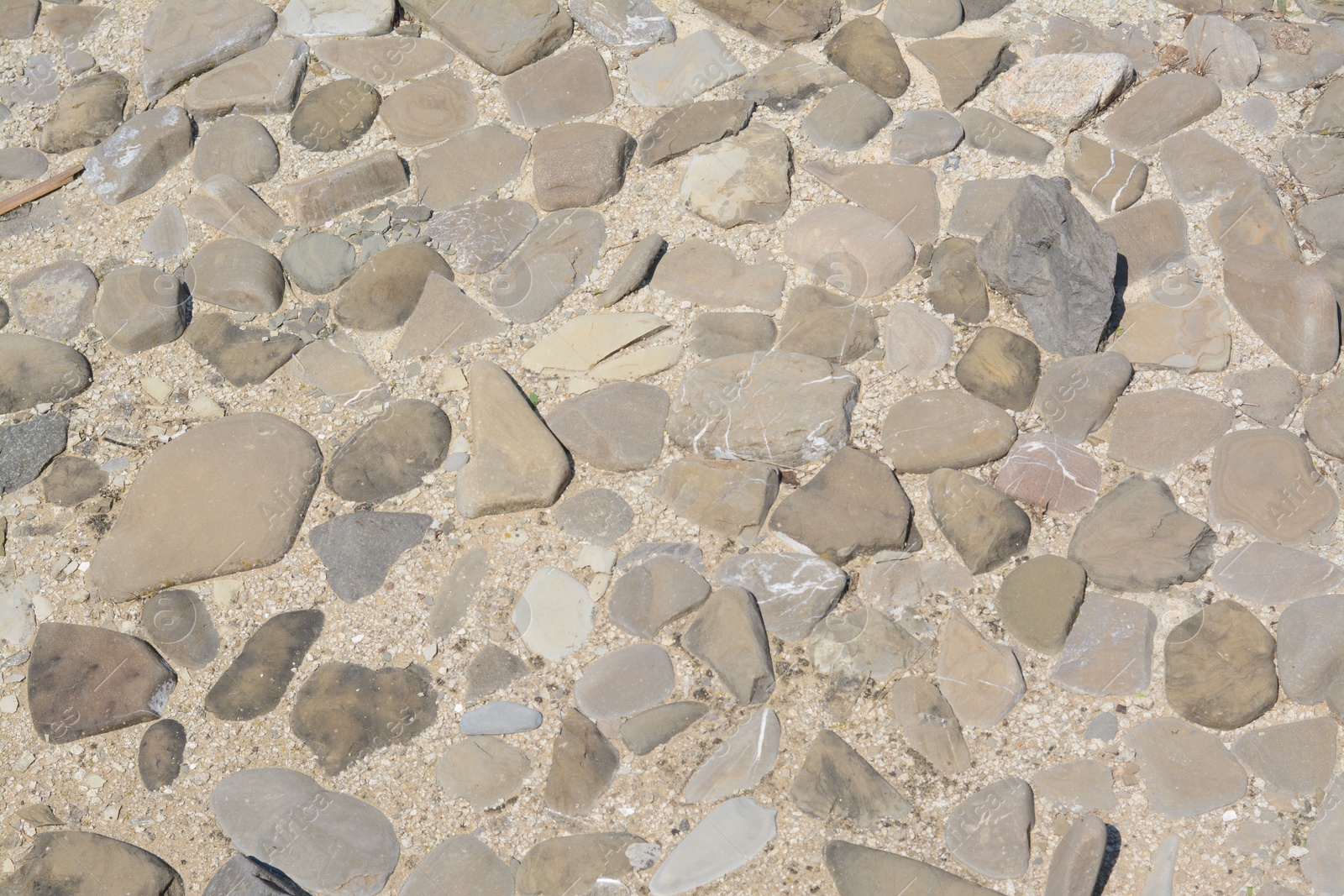 Photo of Surface of ground with different grey stones as background, above view