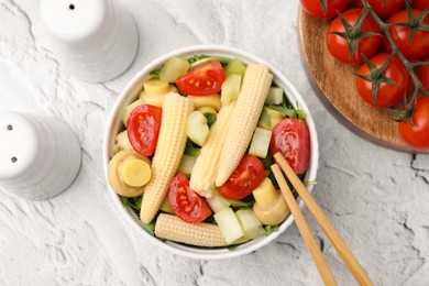 Photo of Tasty baby corn with vegetables and champignons on grey textured table, flat lay