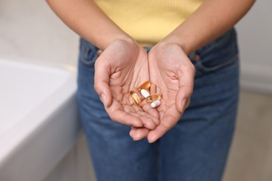 Photo of Woman with vitamin pills at home, closeup