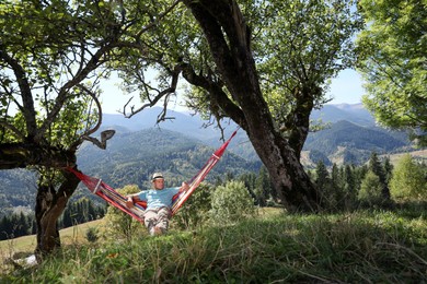 Man resting in hammock outdoors on sunny day