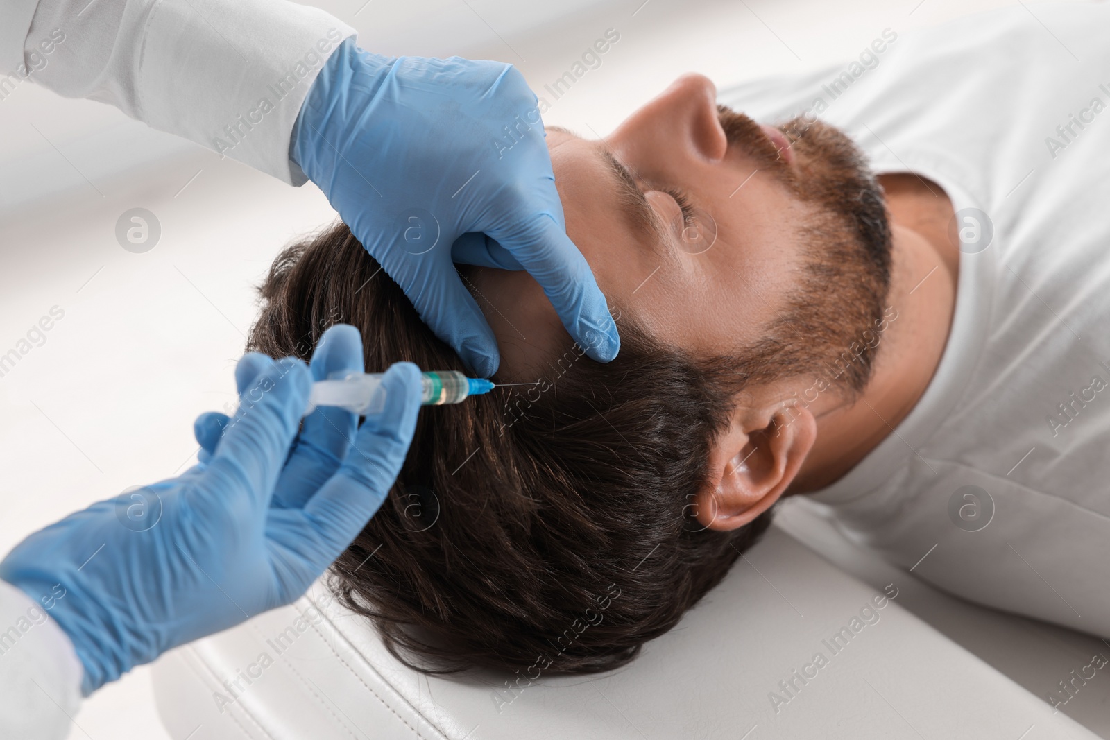 Photo of Trichologist giving injection to patient in clinic, closeup