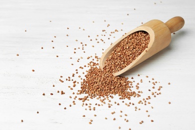 Uncooked buckwheat grains on white wooden table