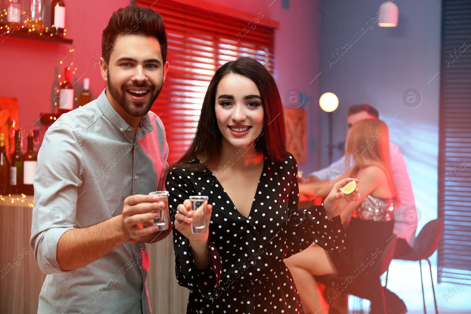 Photo of Young couple with Mexican Tequila shots in  bar