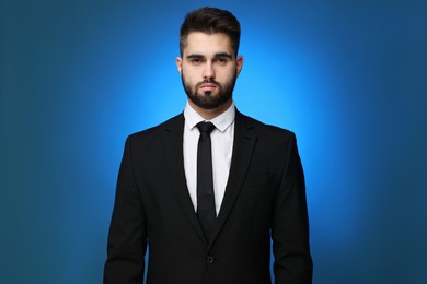 Photo of Handsome businessman in suit and necktie on blue background