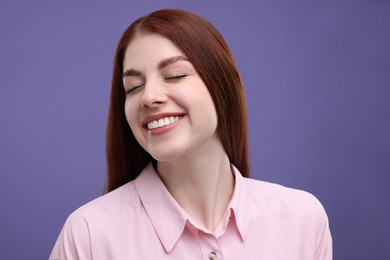 Portrait of smiling woman with freckles on purple background