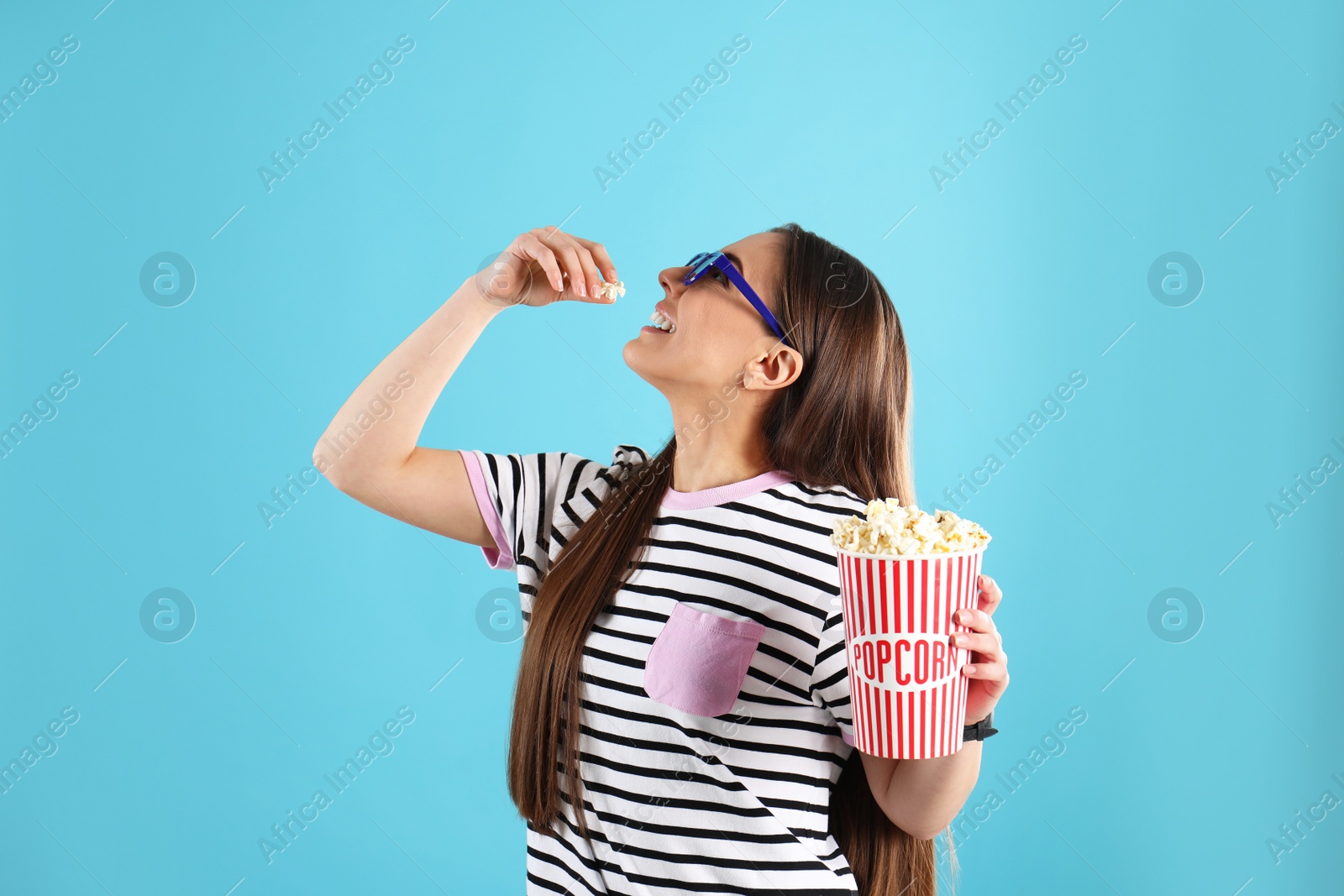 Photo of Young woman with 3D glasses eating tasty popcorn on color background