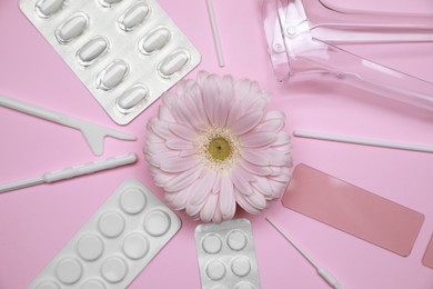 Photo of Gynecological treatment. Sterile tools, pills and gerbera flower on pink background, flat lay