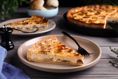 Delicious pie with mushrooms and cheese served on wooden table