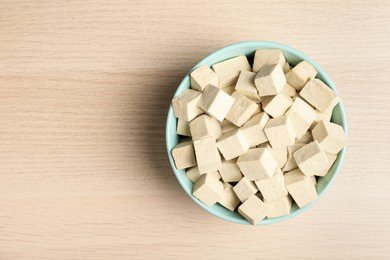 Photo of Delicious tofu on wooden table, top view. Space for text