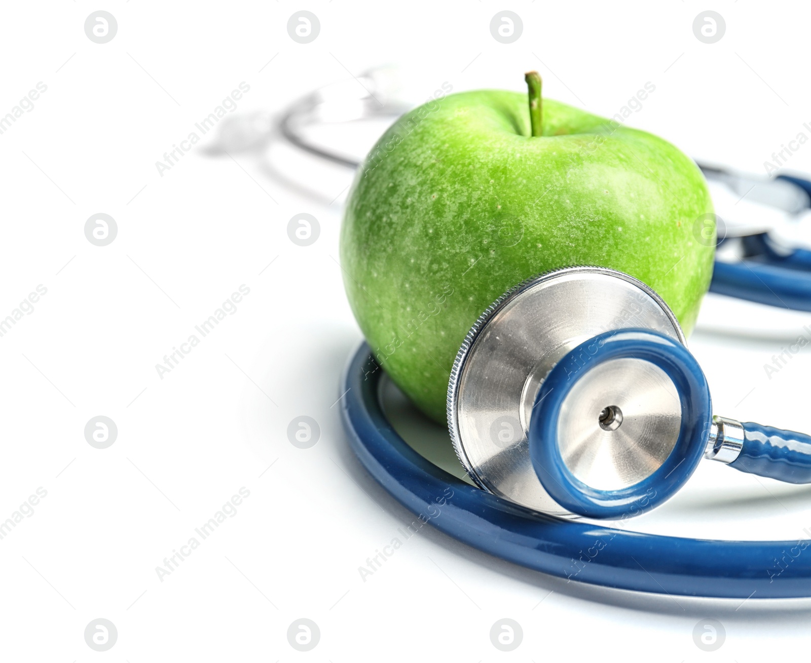 Photo of Stethoscope and apple on light background. Medical equipment