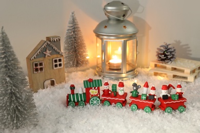 Photo of Toy train and Christmas decor on snow