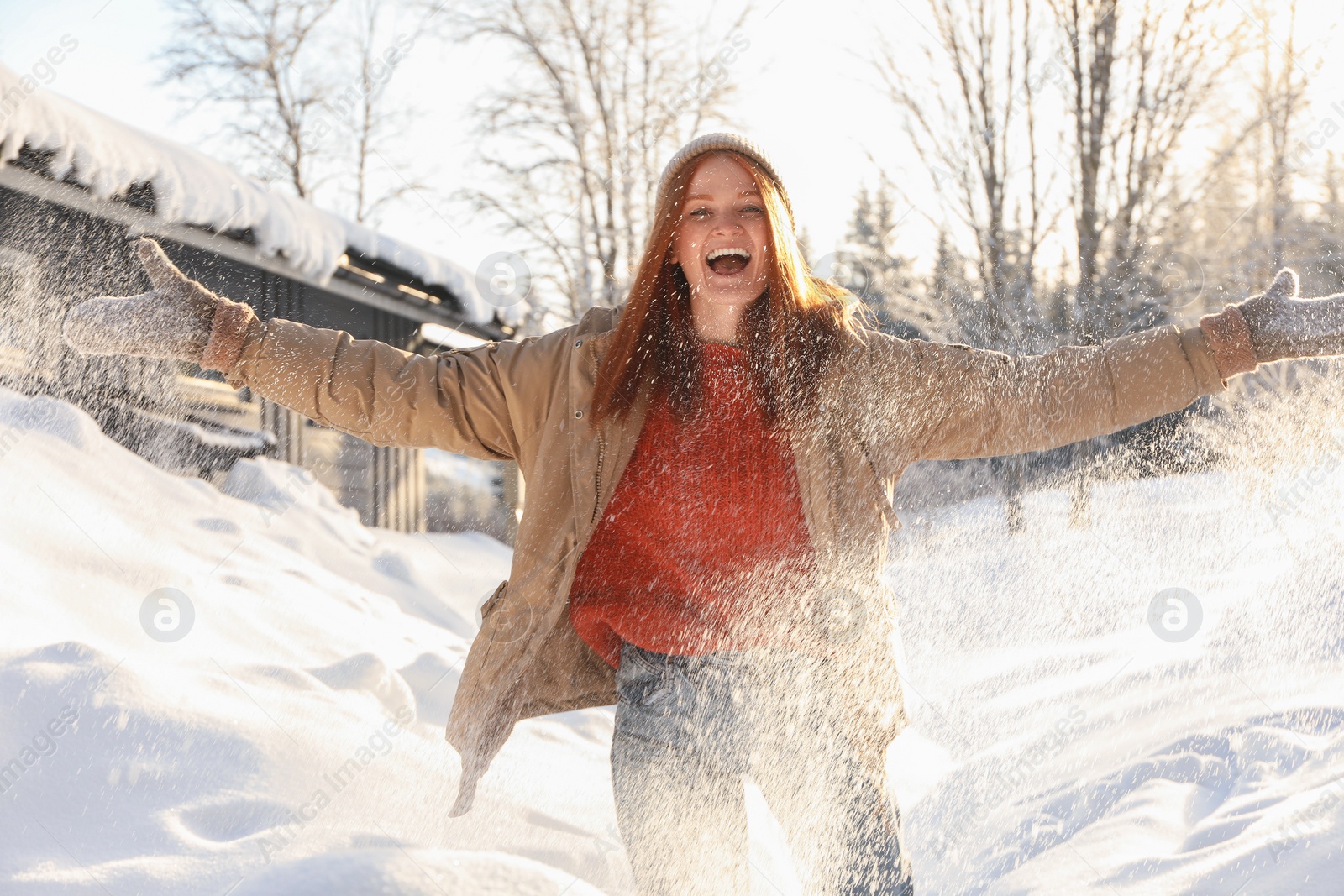 Photo of Emotional woman playing with snow outdoors. Winter vacation