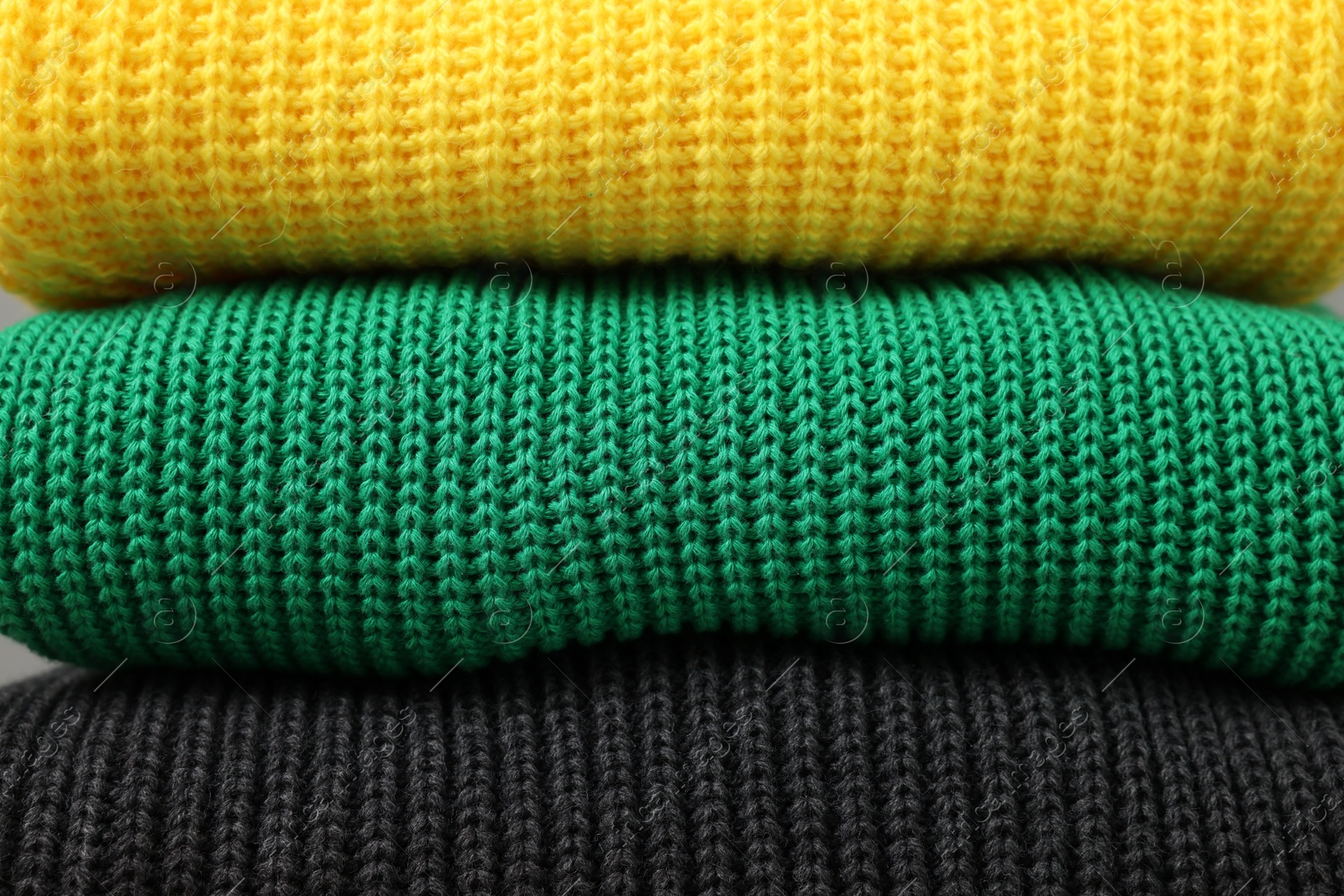 Photo of Stack of casual warm sweaters as background, closeup view