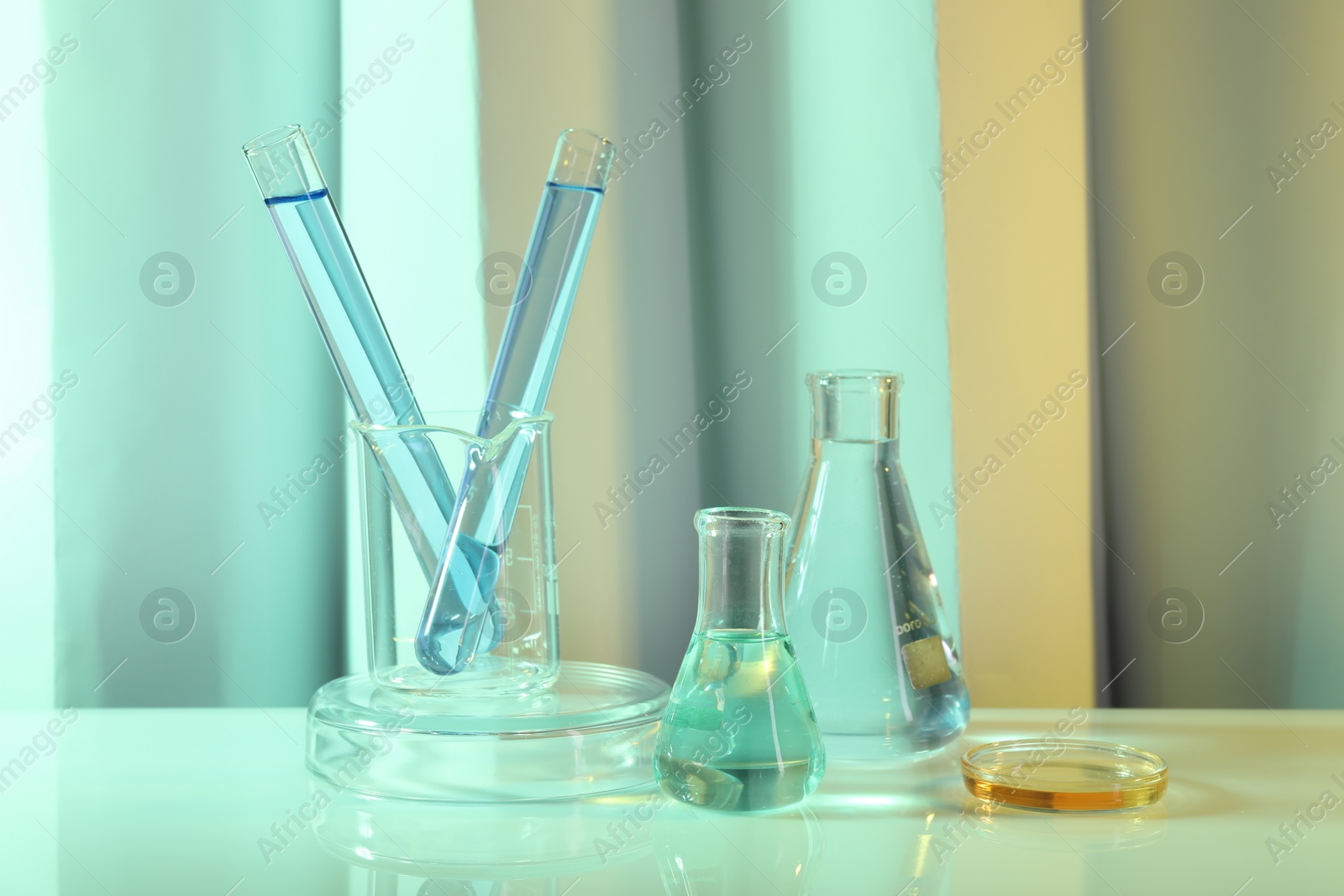 Photo of Laboratory analysis. Different glassware on table against color background