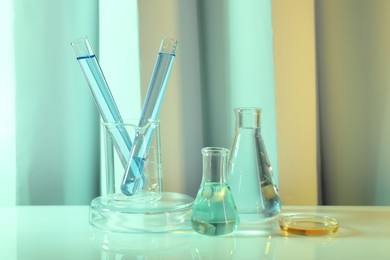 Laboratory analysis. Different glassware on table against color background