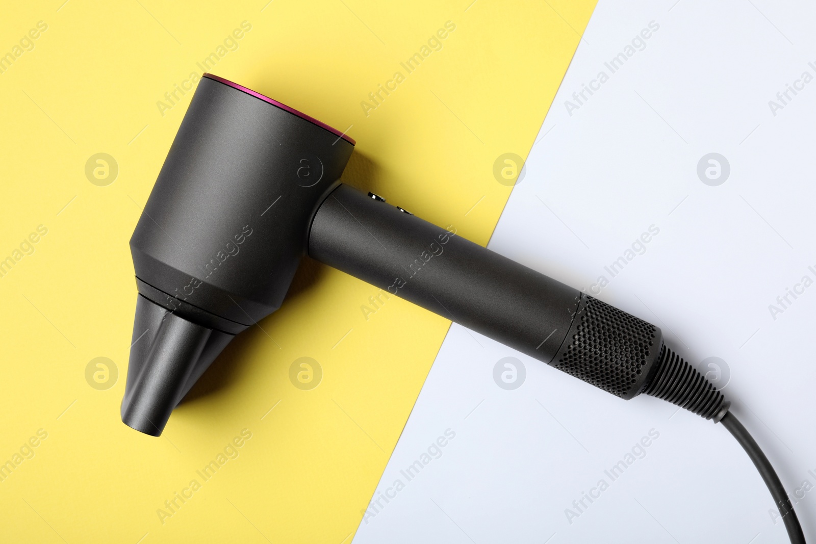 Photo of Hair dryer on color background, top view. Professional hairdresser tool