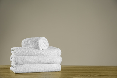 Clean bath towels on wooden table. Space for text