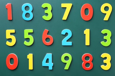 Photo of Colorful numbers on green background, flat lay