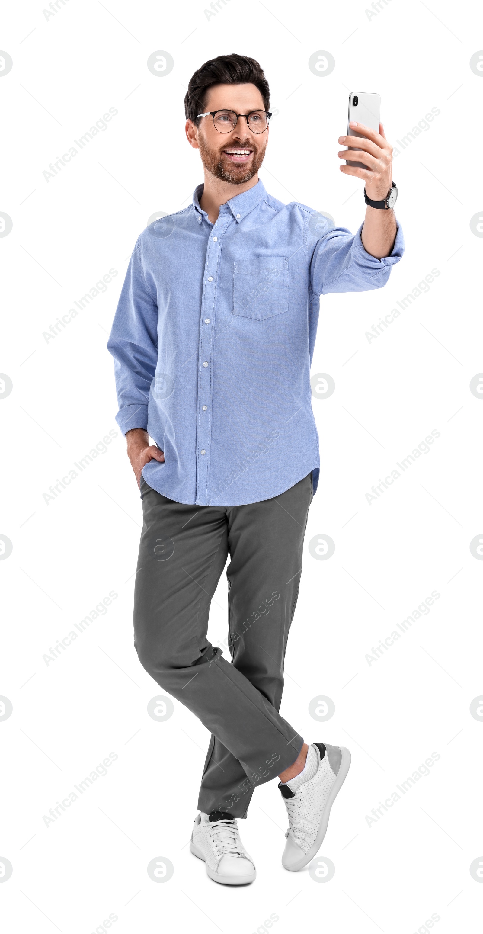 Photo of Smiling man taking selfie with smartphone on white background