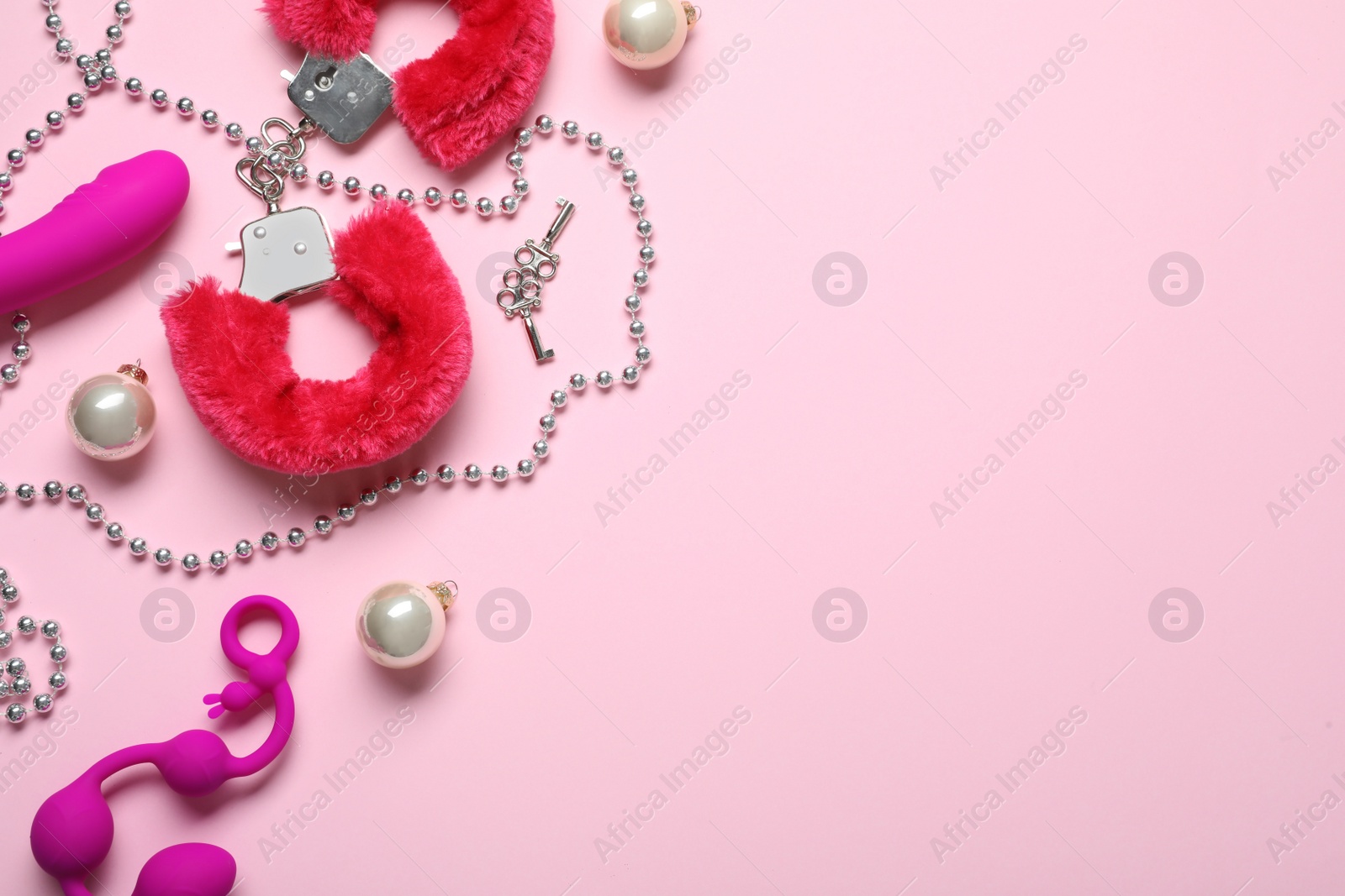 Photo of Set of different sex toys and Christmas decorations on pink background, flat lay. Space for text