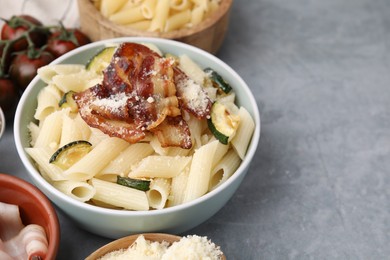 Photo of Tasty pasta with bacon and cheese on grey table, space for text