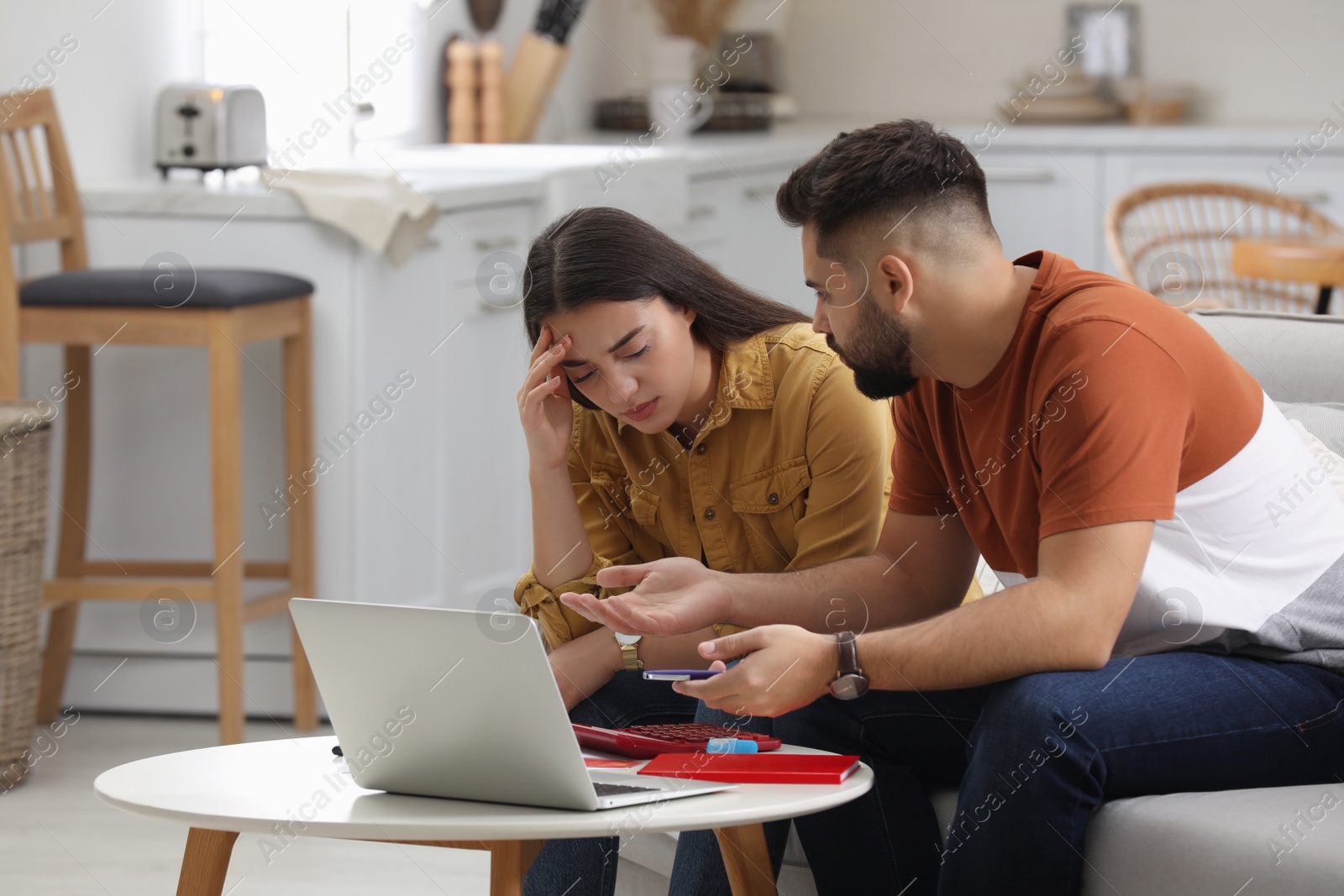 Photo of Young couple discussing family budget at home