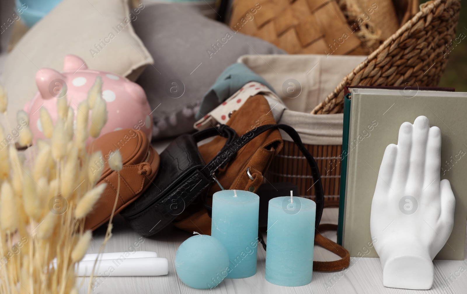 Photo of Many different items on white wooden table outdoors. Garage sale