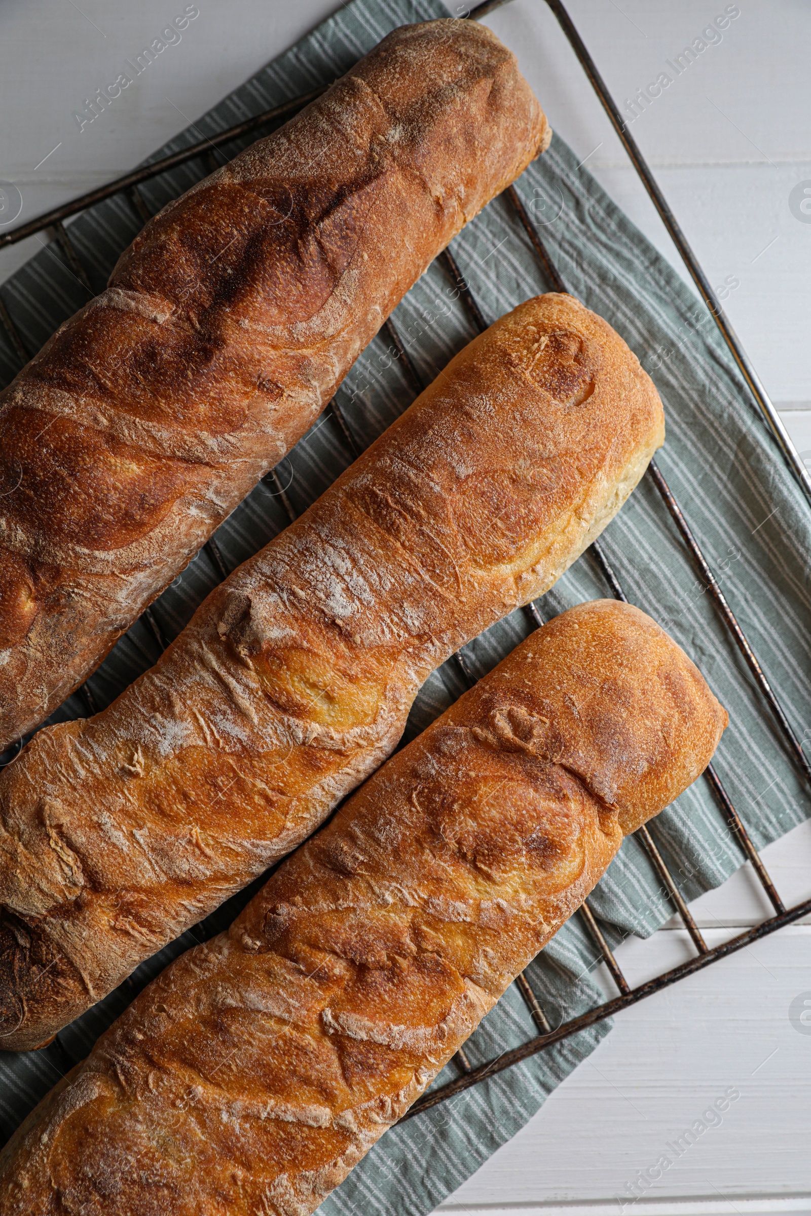 Photo of Fresh crispy ciabattas on white wooden table, top view