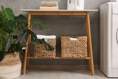 Photo of Storage baskets with towels and houseplant indoors