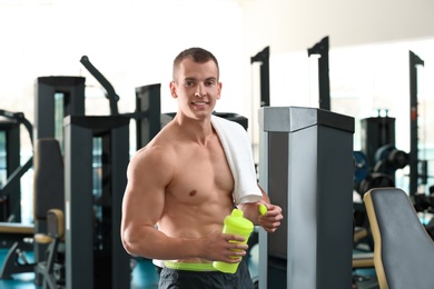 Photo of Athletic young man with protein shake in gym