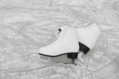 Photo of Pair of figure skates on ice, space for text