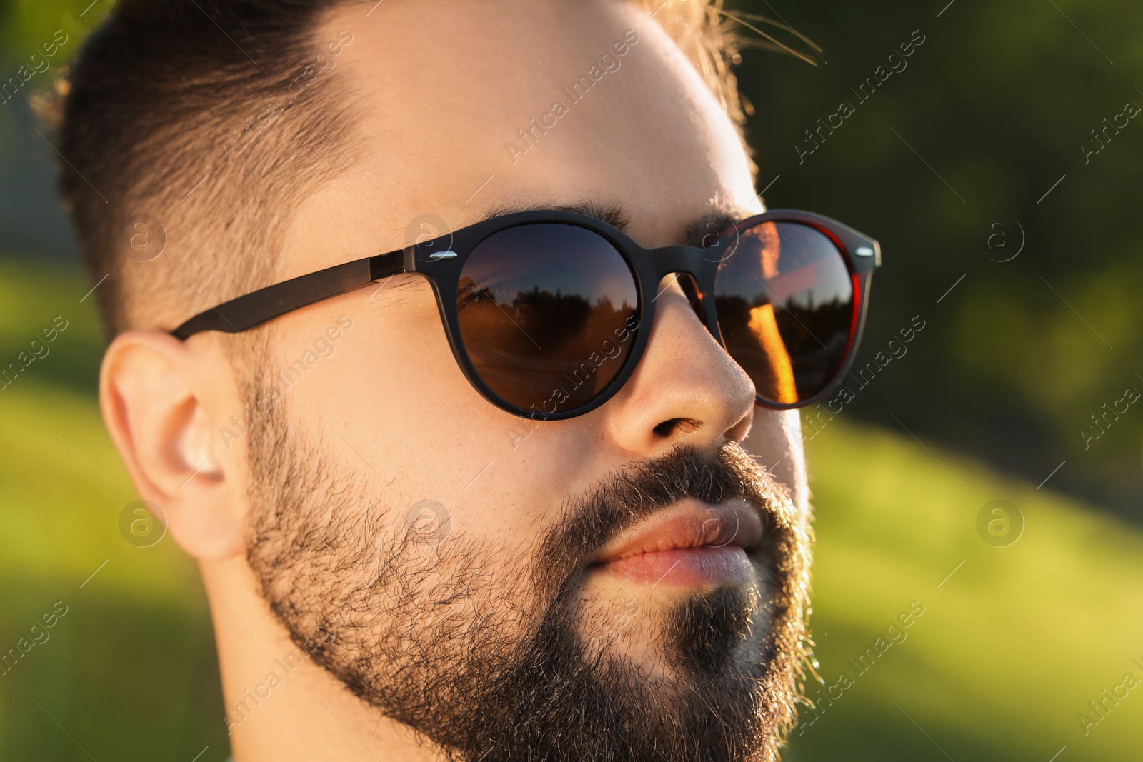 Photo of Handsome man in sunglasses outdoors, closeup. Space for text