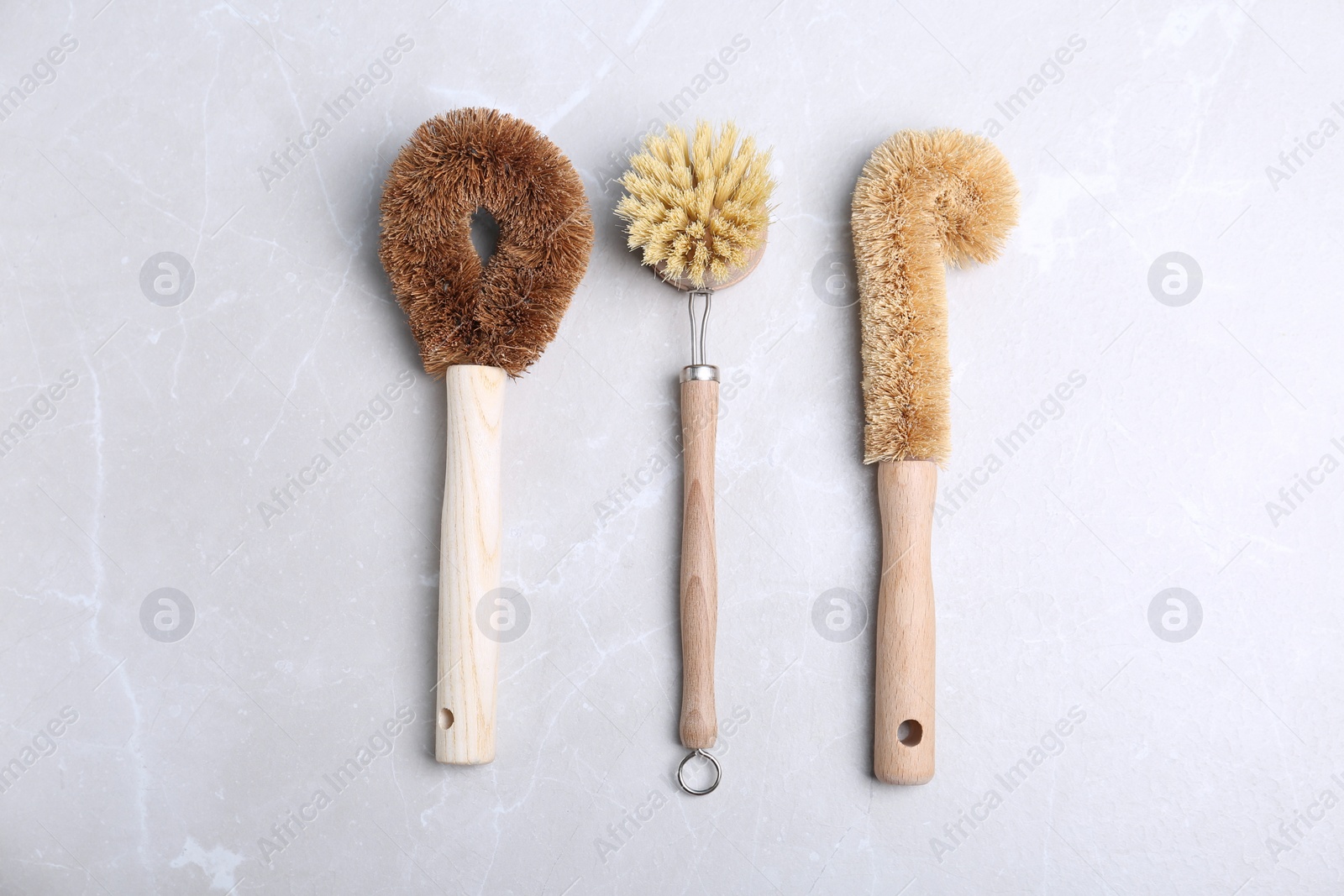 Photo of Cleaning brushes for dish washing on grey table, flat lay